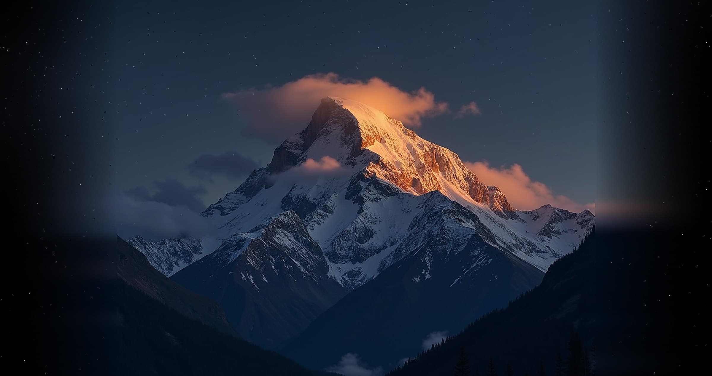 A snow-capped mountain peak at last light, cloud caught around the summit and gold on the upper ridge.